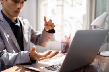 Bir masanın önünde dizüstü bilgisayarın önünde çalışan bir iş adamı.