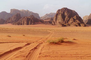 Wadi Rum Çölü, Jordan. Ay Vadisi. Kızıl kum, dağlar ve sis. UNESCO Dünya Mirası Alanı olarak tanımlanıyor. Ulusal park manzarası. Offroad maceraları seyahat arka planı.