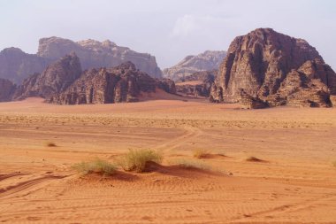 Wadi Rum Çölü, Jordan. Ay Vadisi. Kızıl kum, dağlar ve sis. UNESCO Dünya Mirası Alanı olarak tanımlanıyor. Ulusal park manzarası. Offroad maceraları seyahat arka planı.