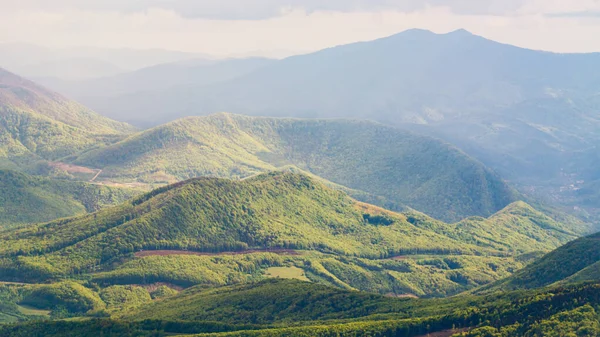Yeşil dağlı ve bulutlu gökyüzü