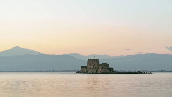 Beautiful view of Nafplio city in Greece. Bourtzi castle on the water. Summer vacations, sunrise time.