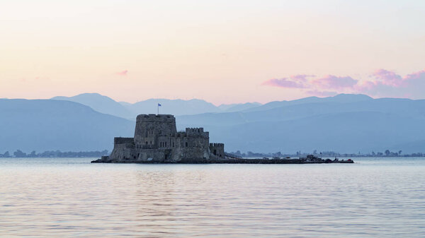 Beautiful view of Nafplio city in Greece. Bourtzi castle on the water. Summer vacations, sunset time.