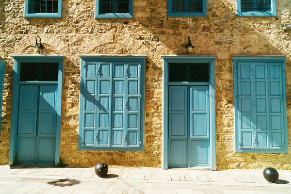 Sarı taş duvarlarda mavi ahşap kapılar ve pencereler. Yunanistan, Nafplion.