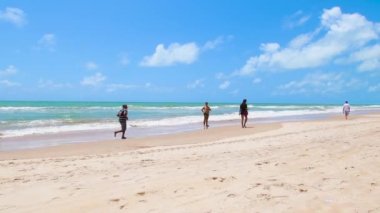 Recife, PE, Brezilya - 14 Ekim 2021: Boa Viagem plajında yıkanır. İnsanlar güzel güneşli bir günde sahilde günün tadını çıkarıyorlar. Sağa doğru video hareketi.