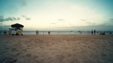 Ipojuca, Beden Eğitimi, Brezilya - 15 Ekim 2021: Porto de Galinhas plajında gece çöküşü, deniz manzarası, yemek arabaları ve günün sonunda sahilde gezinen insanlar..