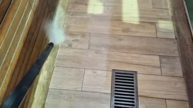 Elektrik süpürgesinin suyuyla ahşabı taklit eden zemini yıkamak..
