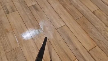 Elektrik süpürgesinin suyuyla ahşabı taklit eden zemini yıkamak..