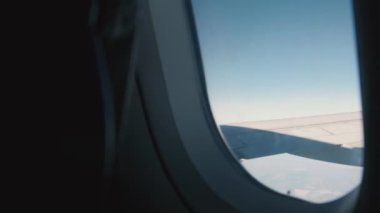 View from the plane window to the wing on a beautiful blue sky day during a flight. Passenger view.