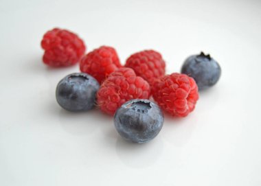 Beyaz arka planda ahududu ve yaban mersini. Beyaz arka planda izole edilmiş taze ahududu ve yaban mersini..