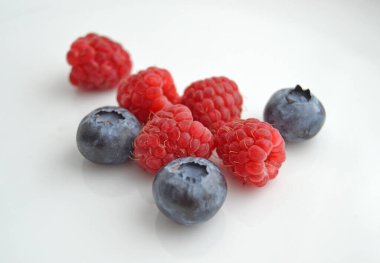 Beyaz arka planda ahududu ve yaban mersini. Beyaz arka planda izole edilmiş taze ahududu ve yaban mersini..