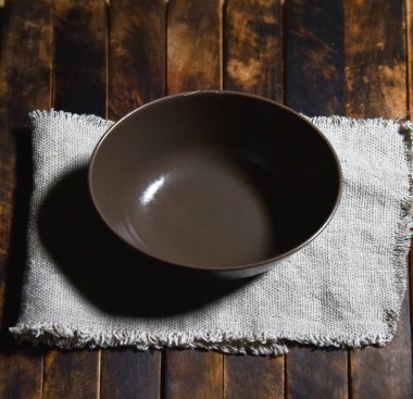 Tahta masa manzaralı boş kahverengi bir tabak.