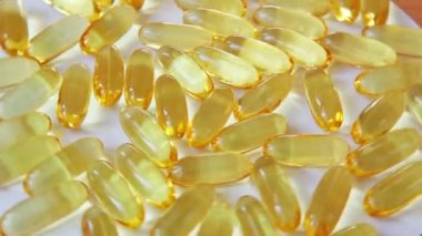 Balık yağı içeren Omega 3 kapsülleri beyaz arka planda, sağlıklı yaşam tarzında ve besin takviyesi kavramında hareket eder