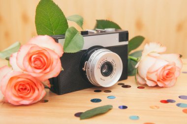 Old film camera with roses flowers, beautiful vintage card