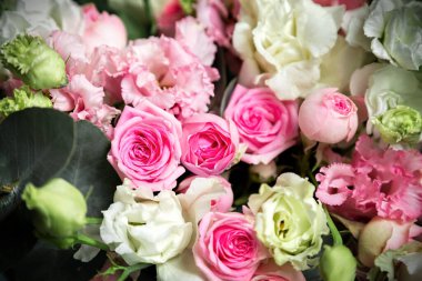 Şakayık gülünden, karanfilden, Lisianthus çiçeklerinden oluşan ve çerçevenin ortasında seçici bir odak noktası olan yakın çekim buketi.