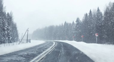 Kış yolu, kar, kar fırtınası, görüş mesafesi zayıf. Yumuşak odaklanma. Bulanık arkaplan