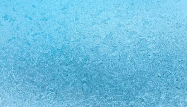 Fondo abstracto de invierno. Patrones de hielo helados en la ventana — Foto de Stock