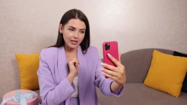 Koltukta video dersi, yüz fotoğrafı, blog konsepti. Genç Amerikalı kadın.