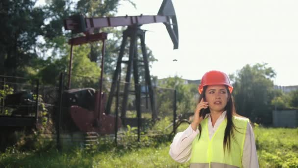Έννοια μείωση της παραγωγής πετρελαίου. Πτώση τιμών. Γυναίκα με τηλεφωνική εξέδρα πετρελαίου. — Αρχείο Βίντεο