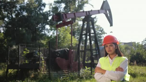 Retrato de engenheiro feminino contra fundo de equipamento de perfuração de petróleo. Mãos ao alto — Vídeo de Stock