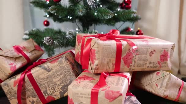 Hermosas cajas de regalo de Navidad en el suelo cerca del abeto en la habitación. Decoraciones de Navidad — Vídeos de Stock