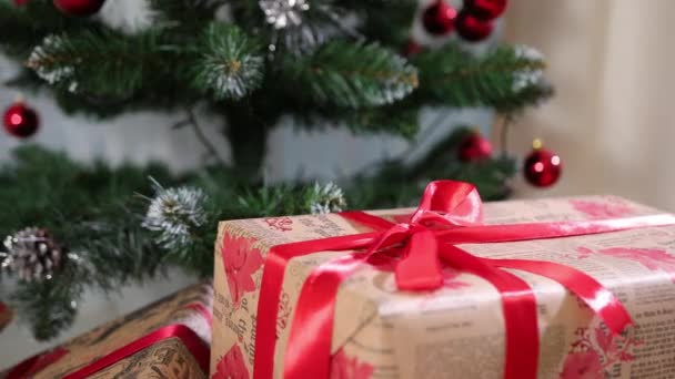 Hermosas cajas de regalo de Navidad en el suelo cerca del abeto en la habitación. Decoraciones de Navidad — Vídeos de Stock