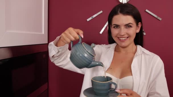 朝はお茶の時間です。台所でお茶を作る女性。閉めろ。肖像画 — ストック動画