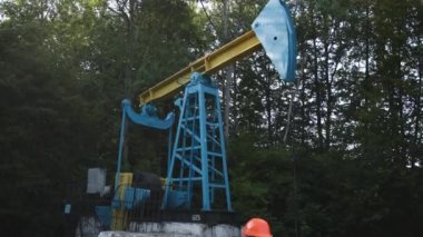 Kadın mühendis tableti elinde tutuyor ve petrol üretimi için hesaplamalar yapıyor.