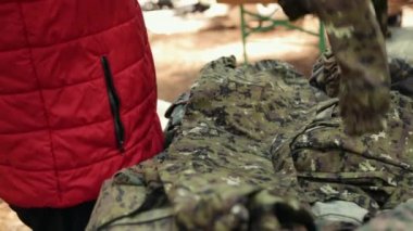 Eller paintball oynamak için askeri üniformaları seçer. Yakın plan..