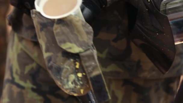 Mans hand puts paint balls in tank of paintball weapons — Stock Video