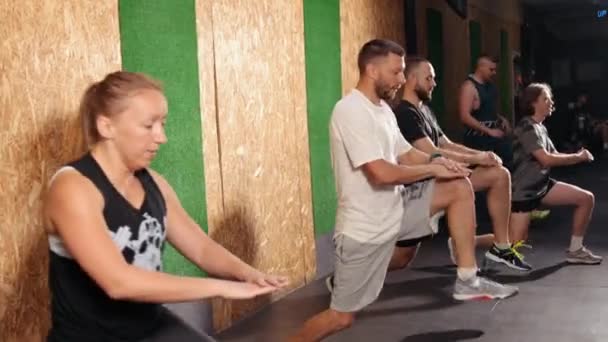 Calentando el entrenamiento. Vista lateral joven hermoso grupo de personas en ropa deportiva — Vídeo de stock