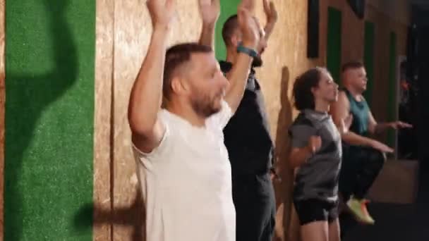 Jovem fitness um grupo de pessoas fazendo saltos jacks star jump exercício em casa — Vídeo de Stock