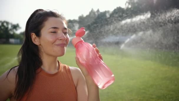 Frau trinkt Wasser, Frau trinkt eine Flasche Flüssigkeit, Porträt der schönen — Stockvideo