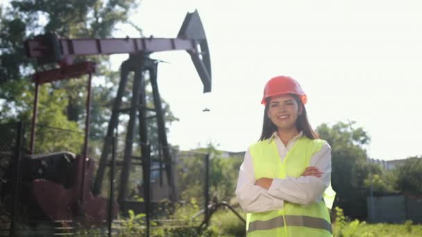 Portret van vrouwelijke ingenieur tegen de achtergrond van olieboorinstallatie. Handen omhoog. — Stockvideo