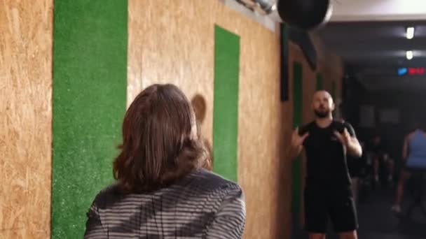 Schöne europäische Männer wirft Crossfit Ball. Männchen in Sportkleidung im Kreis — Stockvideo
