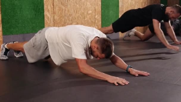 Plein plan groupes athlètes engagés dans le sport, détournant les yeux faisant push-ups — Video