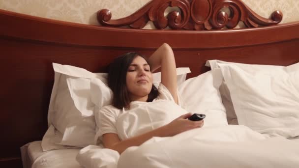 Woman is watching show. Lady resting at home. Person watch tv set on the bed — Video Stock