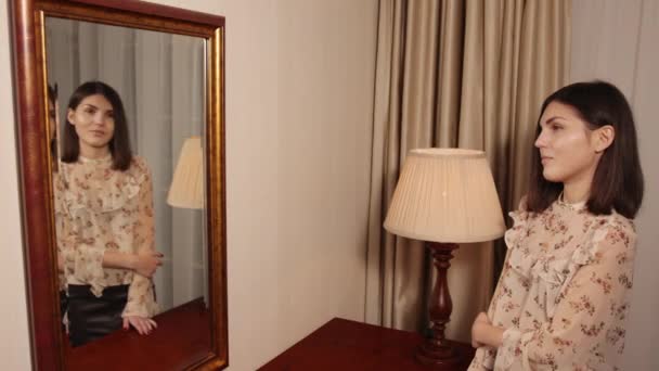 Gyönyörű divatmodell nő pózol a tükör közelében. A hölgy a tükörképét nézi. — Stock videók