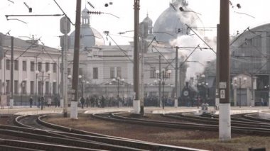 Retro buhar treni tren istasyonundan ayrılıyor. Mavi arabalı eski siyah buhar treni