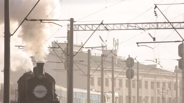 Tren de vapor retro sale de la estación de tren. Viejo tren de vapor negro con coches azules — Vídeo de stock