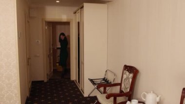 Turist kadın portresi otel odasında bavulla odaya giriyor.