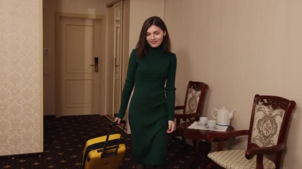 Turystka, która po zameldowaniu wchodzi do pokoju z bagażem w pokoju hotelowym. — Wideo stockowe