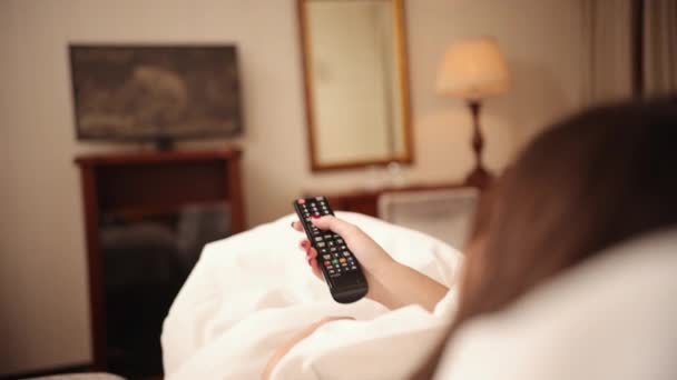 Woman is watching show. Lady resting at home. Person watch tv set on the bed — Video Stock