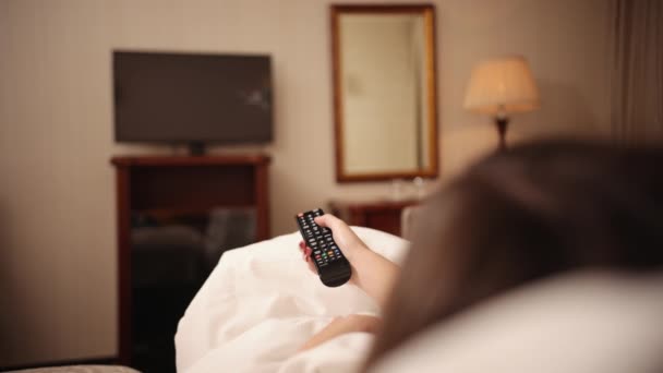 Movies at home on streaming services, tv remote control is in a female hand — 图库视频影像