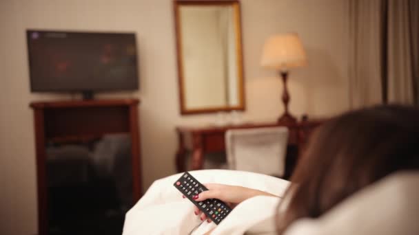 Resting lying down on couch at home, feeling bored sleepy, pointing tv remote — 图库视频影像