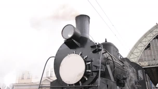 Retro steam train departs from the railway station. Old black steam train with blue cars — 图库视频影像