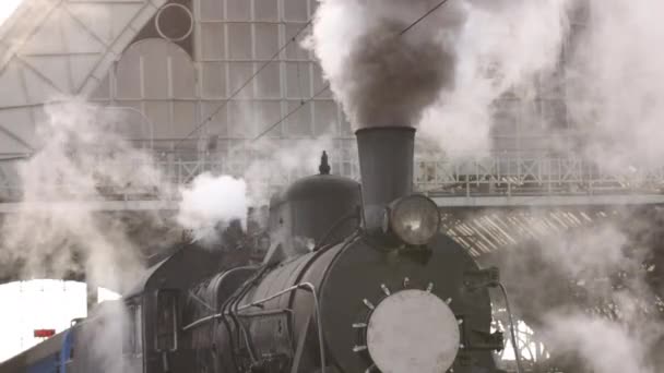 Retro parní vlak odjíždí z nádraží. Starý černý parní vlak s modrými auty — Stock video