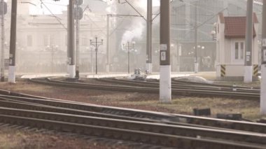 Retro buhar treni tren istasyonundan ayrılıyor. Mavi arabalı eski siyah buhar treni