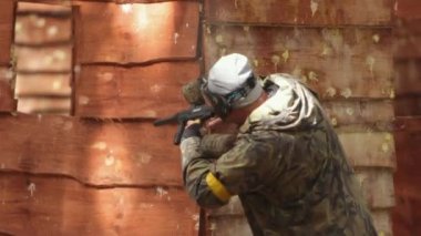 Koruyucu maske takan paintball oyuncusu. Üniformalı oyuncu