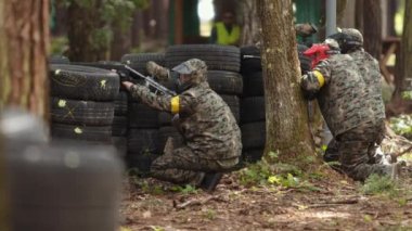 Koruyucu maske takan paintball oyuncusu silah barınağı saldırısını hedefliyor