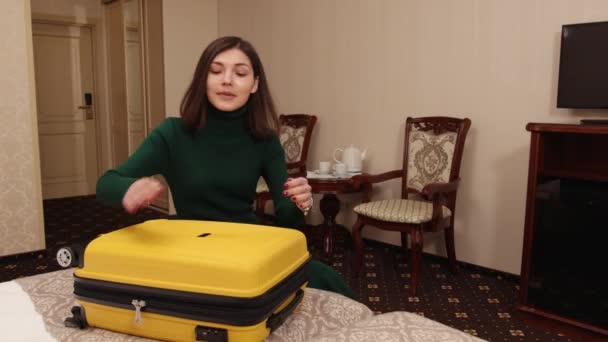 Preparation travel suitcase at home. Open trendy yellow handbag on bed. Open — стокове відео